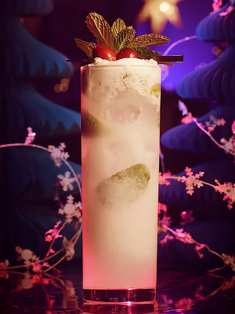 A creamy holiday highball garnished with mint and cranberries