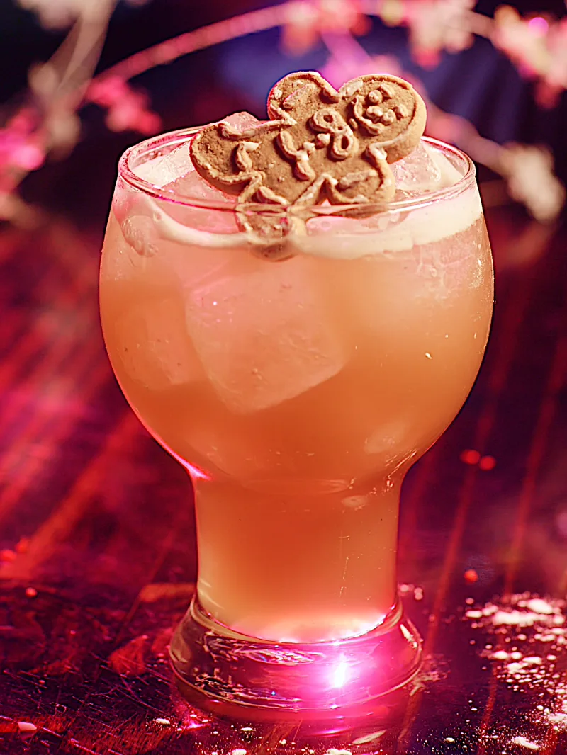 A holiday cocktail topped with a gingerbread cookie