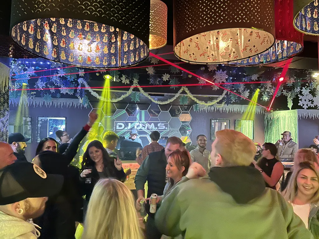 Guests dancing beneath lasers, holiday lights, and snowflakes at Nightingale Cocktail