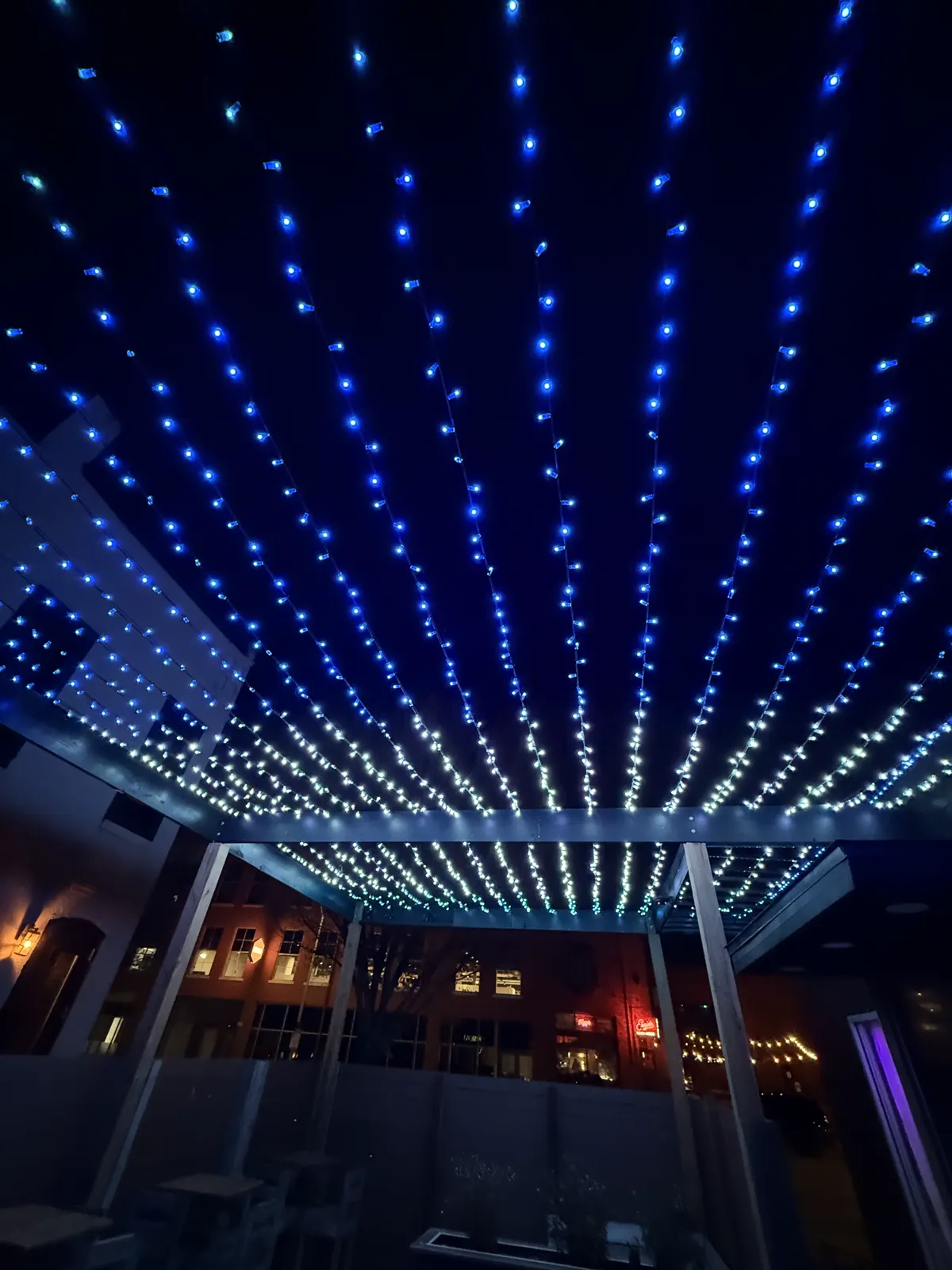 Strings of blue and white holiday lights above the Nightingale Cocktail patio