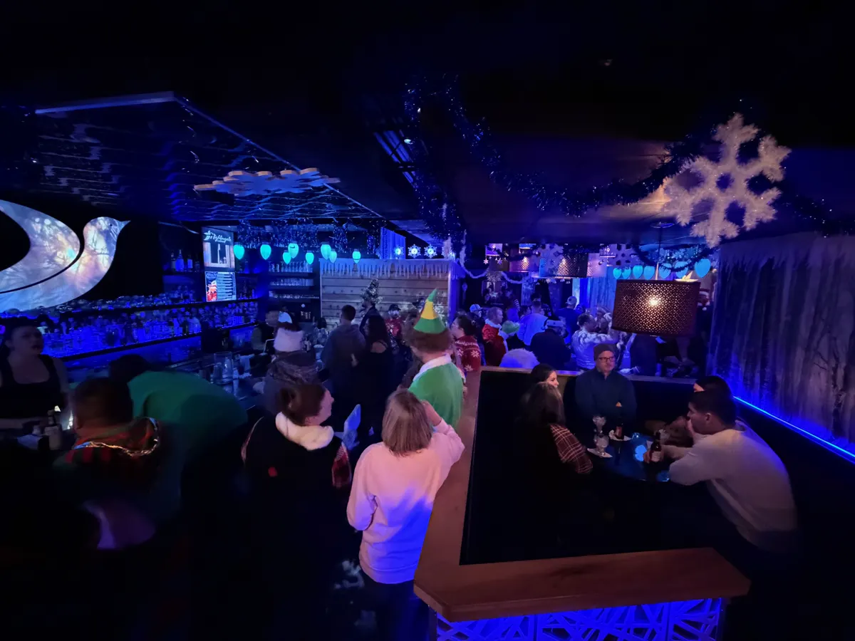 Friends gathered in the Winter Wonderland lounge under oversized snowflakes and glowing blue ornaments